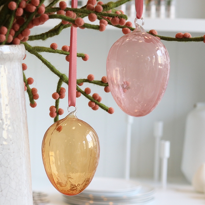 Œuf de Pâques en verre orange avec œillet