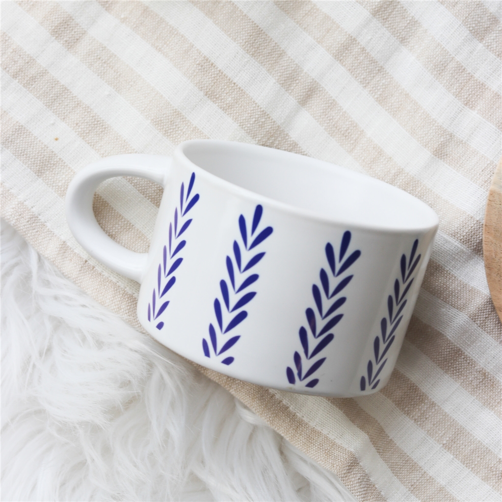 Tasse blanche avec décor folklorique bleu