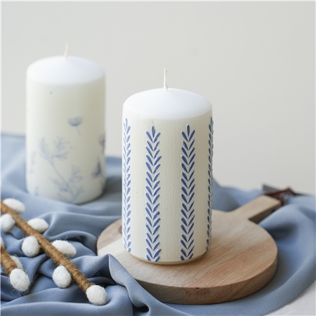 Bougie blanche avec décoration de feuilles
