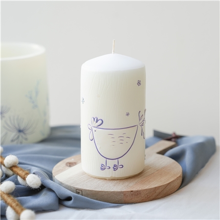 Bougie blanche avec décoration de poule