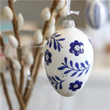 Œuf de Pâques folklorique avec feuilles et fleurs bleues