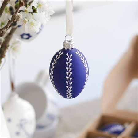 Oeuf de Pâques bleu givré avec décoration de feuilles