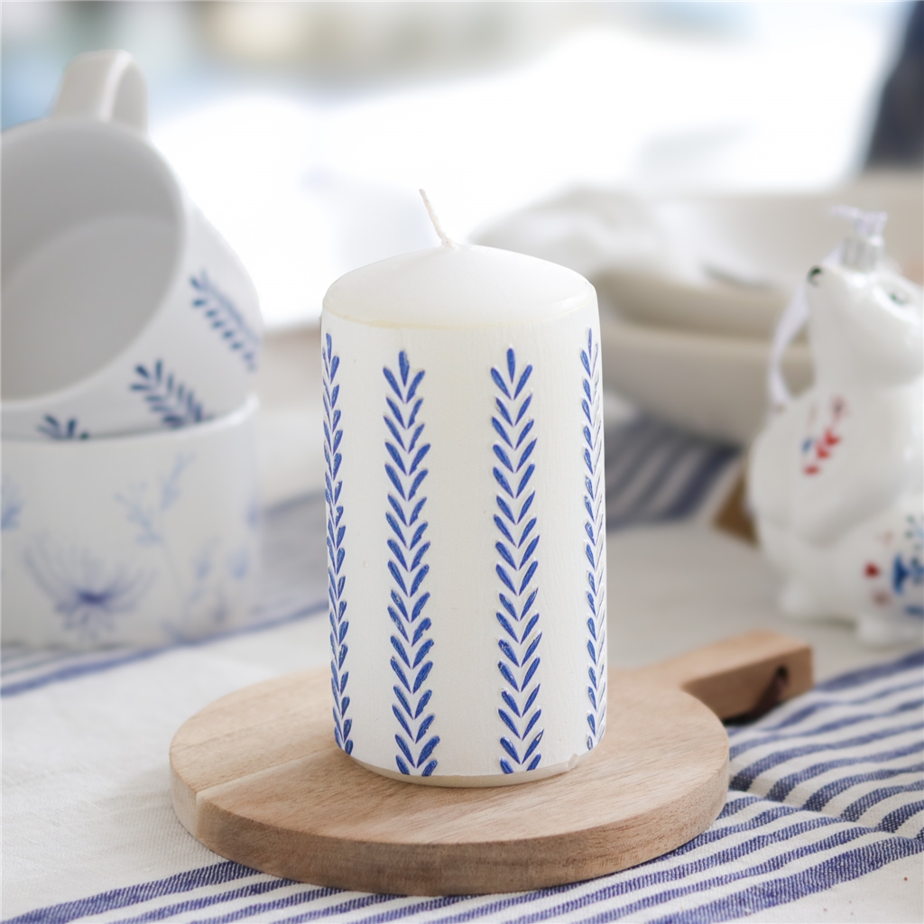 Bougie blanche avec décoration de feuilles