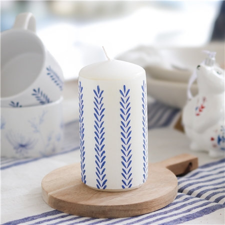Bougie blanche avec décoration de feuilles